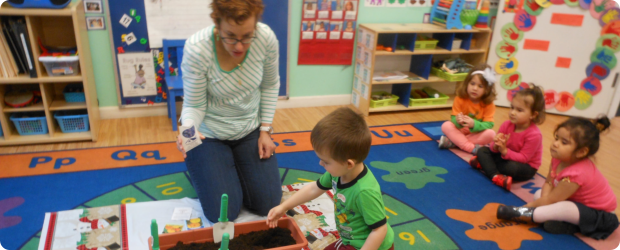 teacher assisting child activity